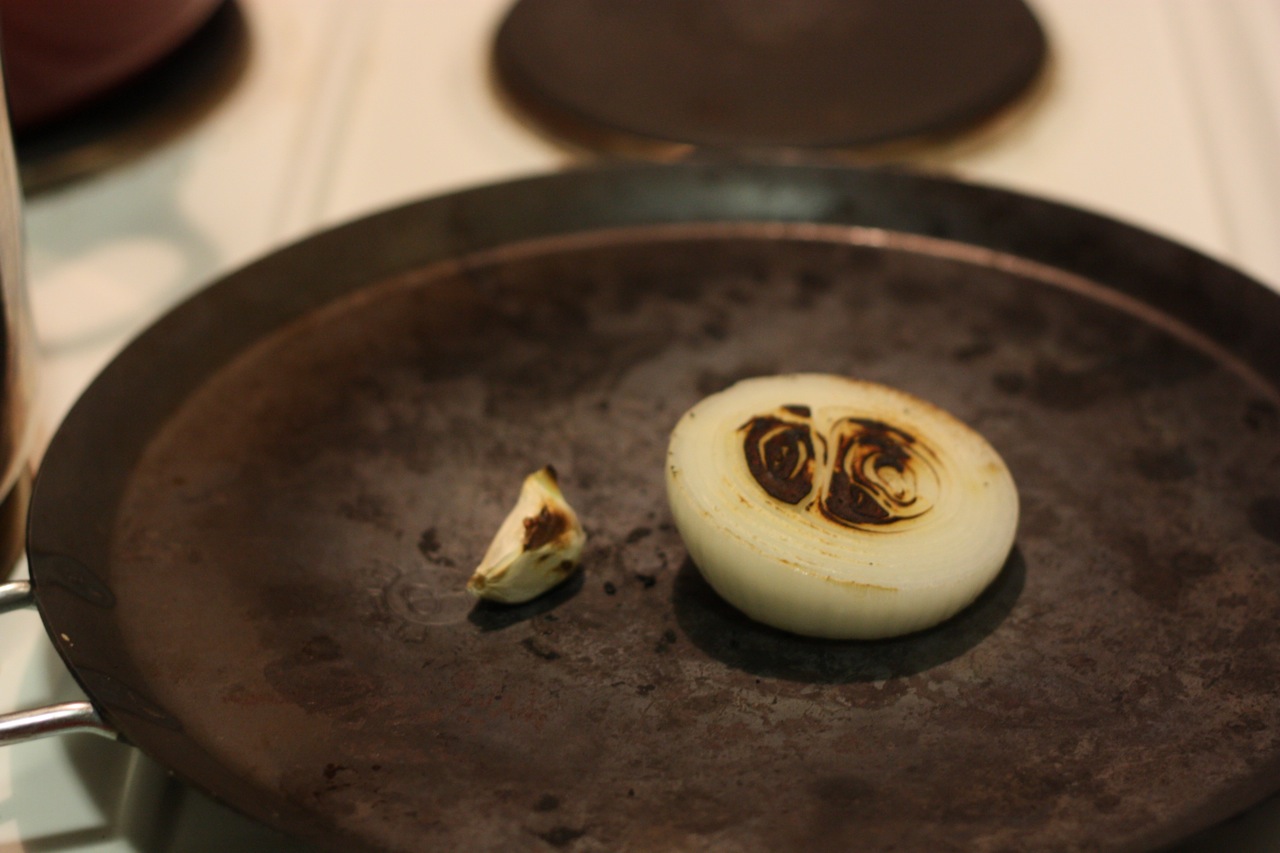 Onion and garlic roasting on a comal
