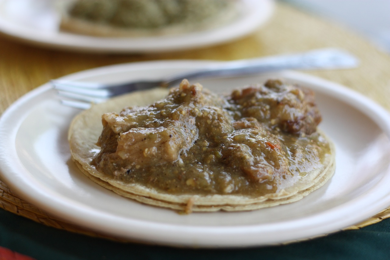An entomatado taco, comprised of pork in a tomatillo sauce
