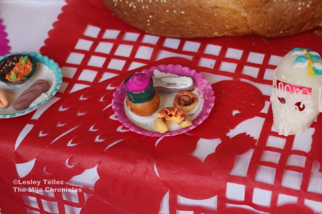 A miniature plate of sweet bread and atole, with rice and mole on the left Food decorations for Day of the Dead altar