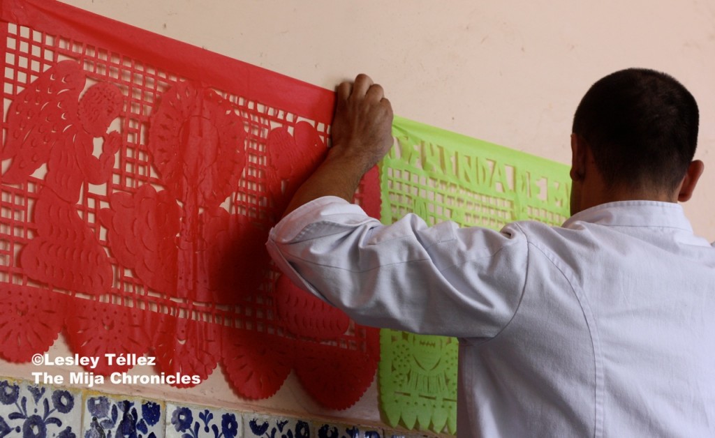 Decorating the wall with papel picado, part of a Day of the Dead course at Mexico City's Escuela de Gastronomía Mexicana Papel picado for Day of the Dead