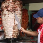Slicing off grilled pork for tacos árabes in Puebla, Mexico